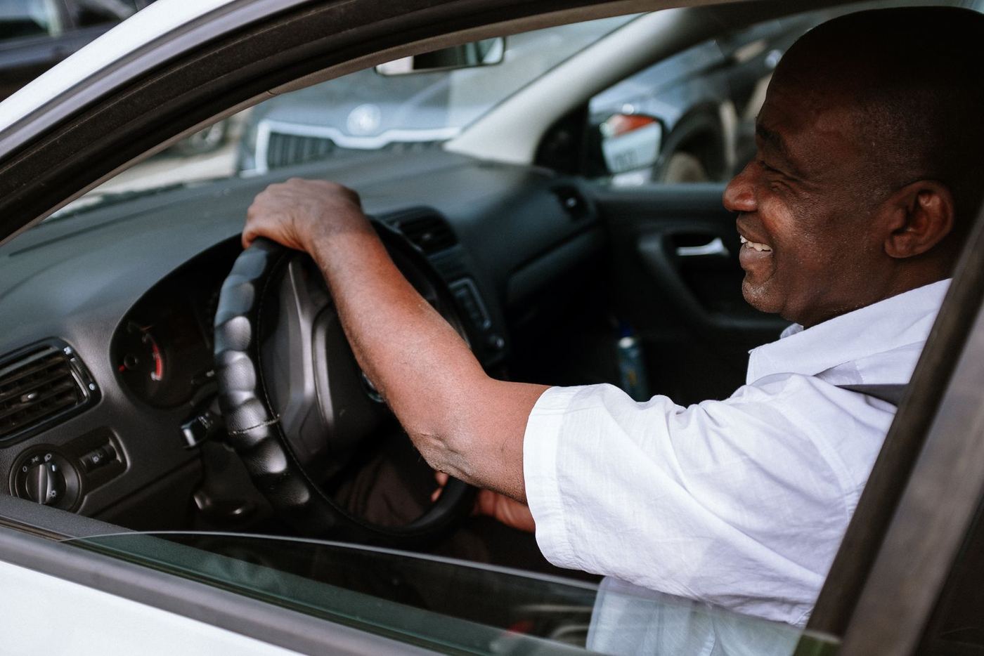 Smiling driver with both hands on the steering wheel